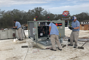 Contractors repairing commercial AC unit